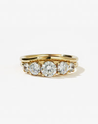 A classic yellow gold, five stone diamond engagement ring. Set with  diamonds and shown with a matching wedding band.
