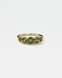 A classic yellow gold, five stone diamond engagement ring. Set with green sapphires.