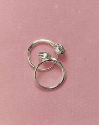 Silver tulip rings on a pink background