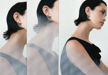 Selene Pearl Earrings
Inspired by both the round structures of brutalist architecture in the Ukraine and flower seeds, the pearl poses as a semi hidden seed, coming out of a cocoon like orb. These elegant stud earrings sit snug along the lobe, creating an impactful shape on the ear which looks beautiful from all angles.