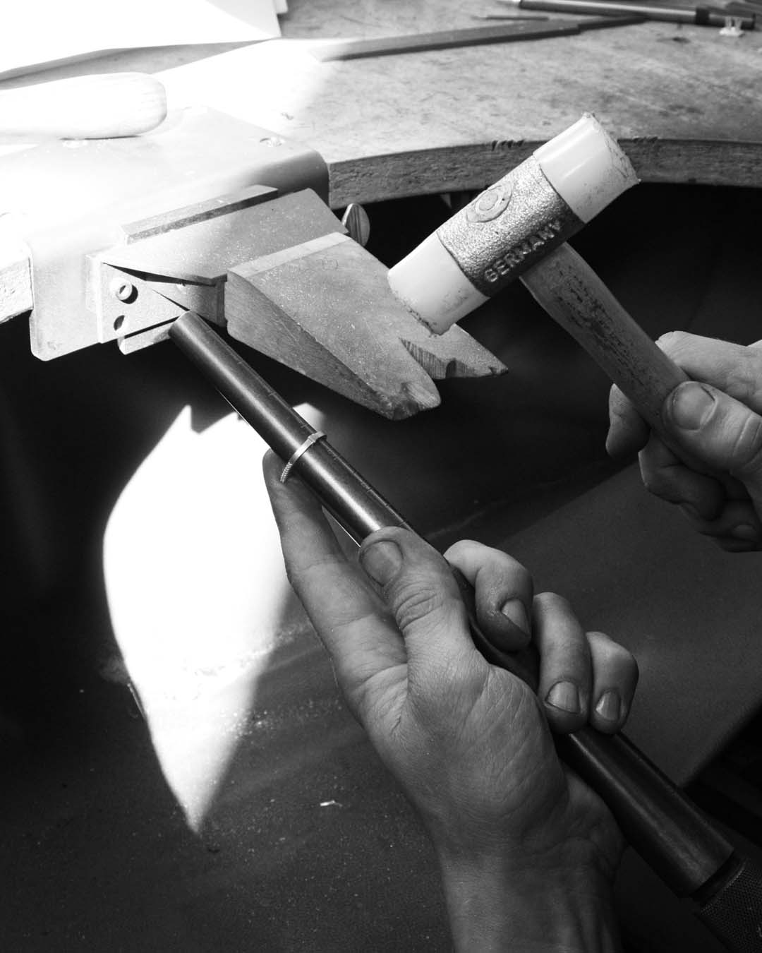 Sizing on a ring bar. To increase the size of the band, it is hammered down a mandrel.