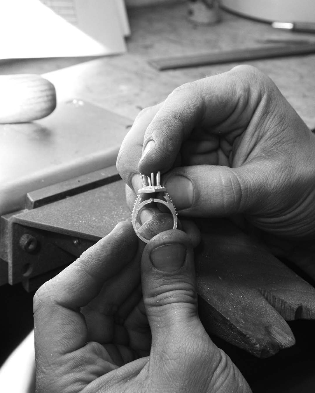 Checking the fit of the setting on the band. He then sands and files the base to ensure it fits snugly on top of the band.