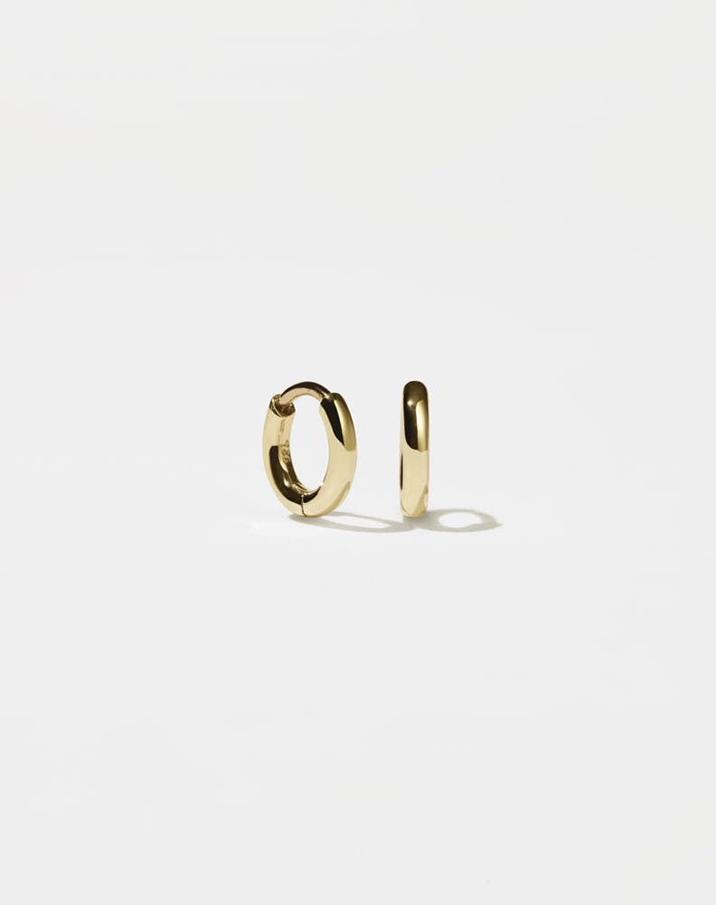 A pair of small, gold-plated hoop earrings with a central hinge, designed to fit close to the earlobe.