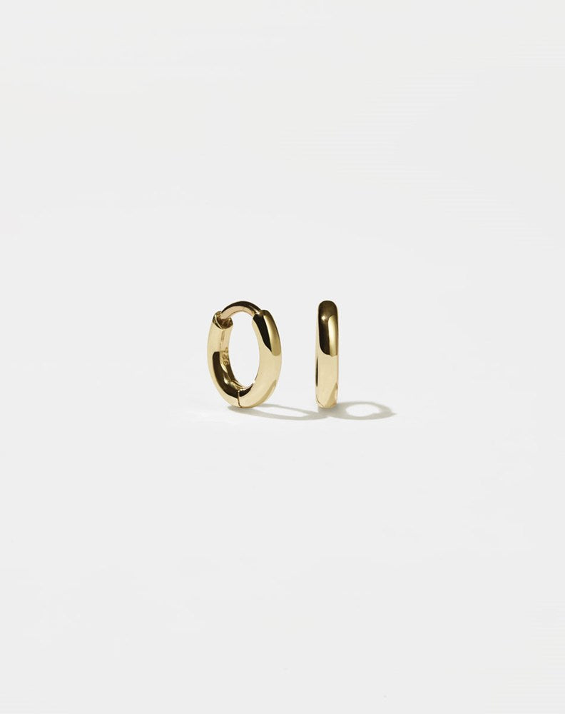 A pair of small, gold-plated hoop earrings with a central hinge, designed to fit close to the earlobe.