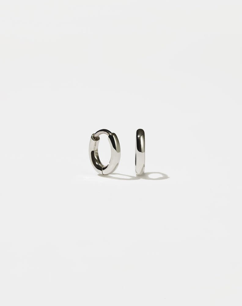 A pair of sterling silver hoop earrings with a central hinge, designed to fit close to the earlobe.