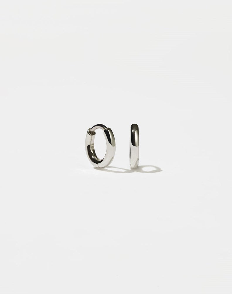 A pair of sterling silver hoop earrings with a central hinge, designed to fit close to the earlobe.