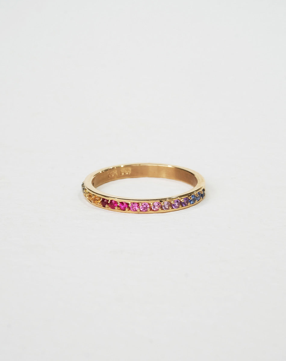 A 9ct yellow gold eternity band ring pave set halfway with colorful rainbow sapphires.
