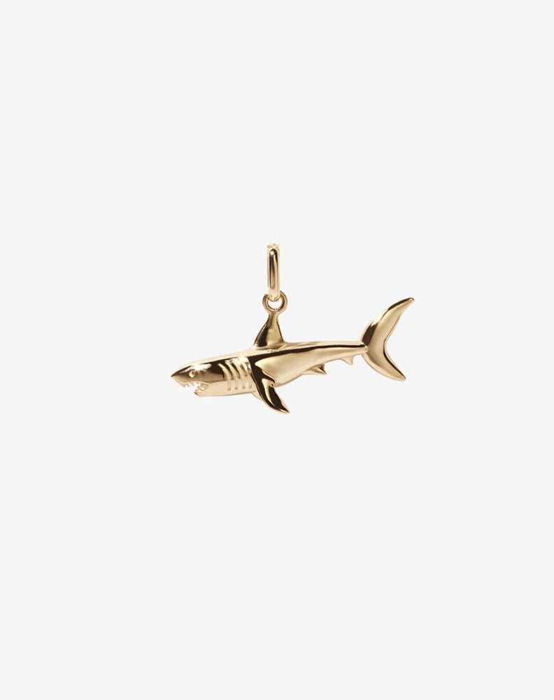 A gold shark charm with an oval jump ring for attachment.