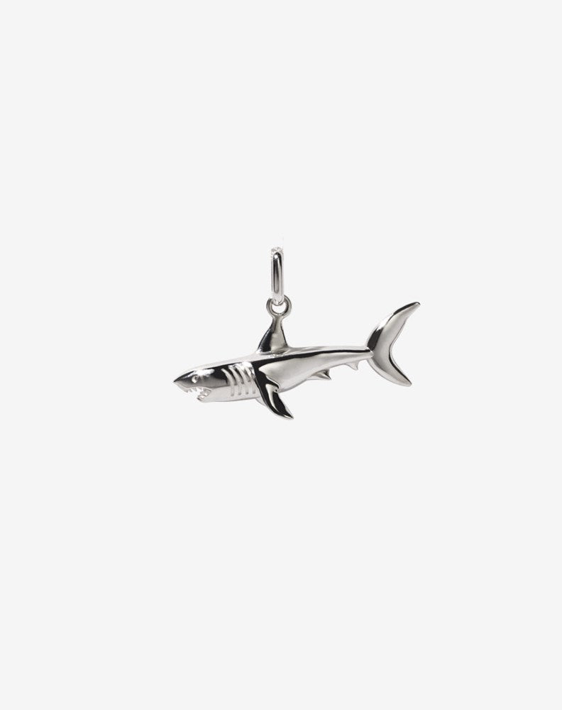 A sterling silver charm in the shape of a shark with an oval jump ring for attaching to a chain.