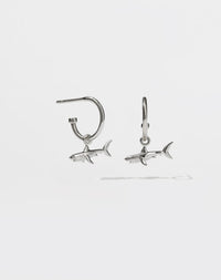 A pair of sterling silver hoop earrings with shark charms attached to them