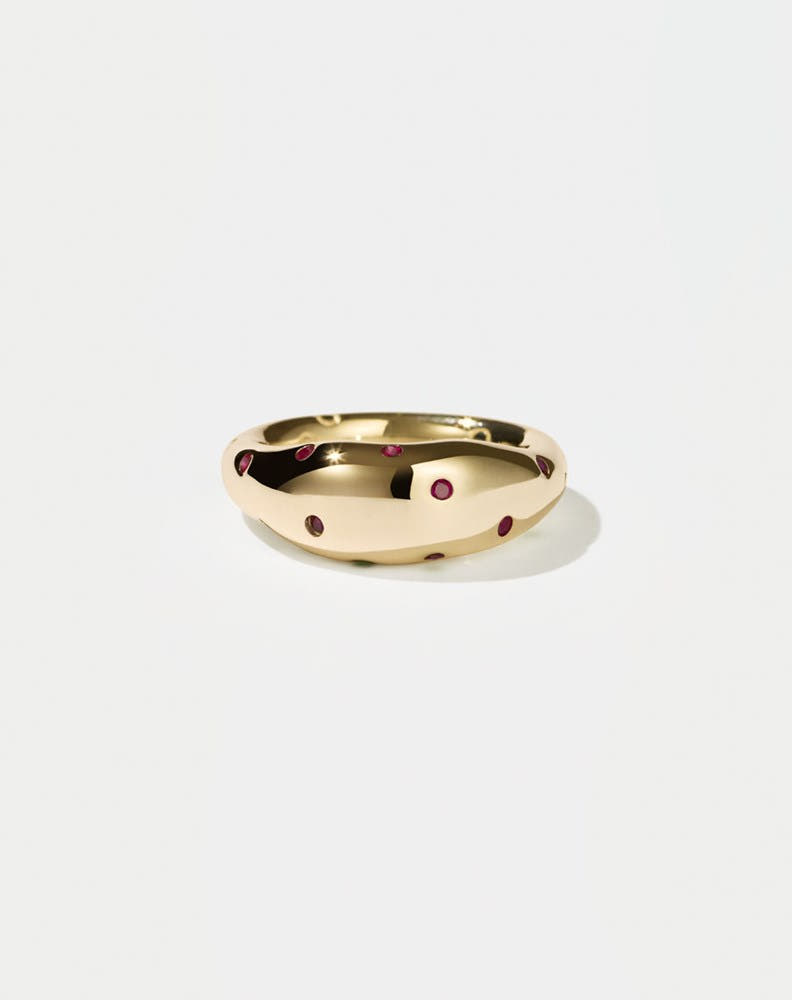 A  gold ring with round brilliant rubies set in Swiss settings