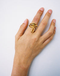 Gold rings stacked on hand, flower ring, peridot stone and twisted band