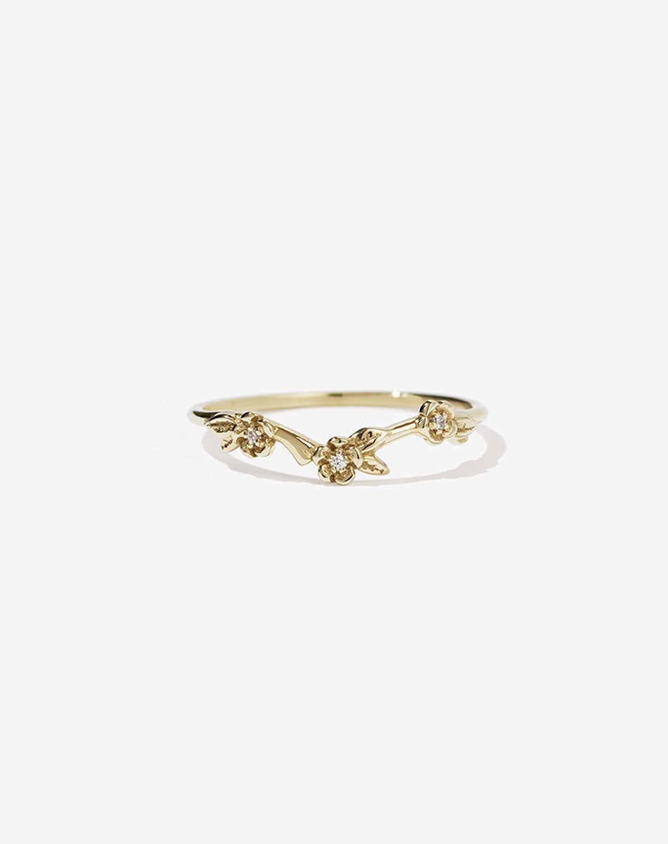 A 9ct yellow gold band ring with a floral design featuring round brilliant stones set within the flowers.