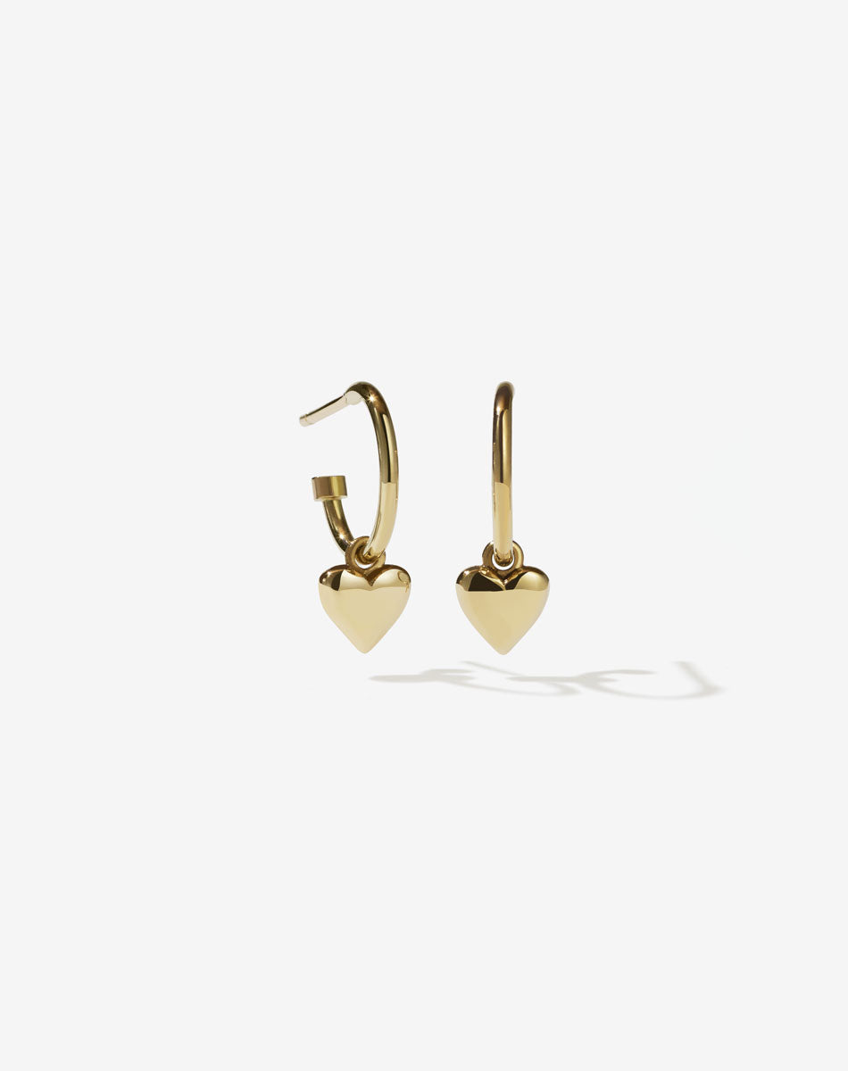 A pair of 9ct solid gold hoop earrings with a small heart charm attached to each hoop.