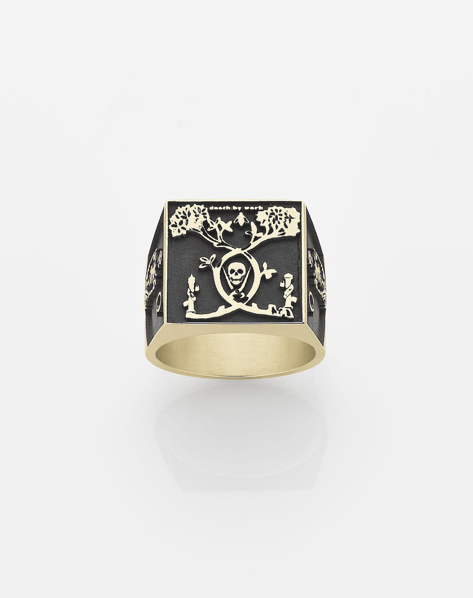 A men's gold ring with an oxidized design featuring a skull and crossbones motif, in collaboration with Andrew McLeod.