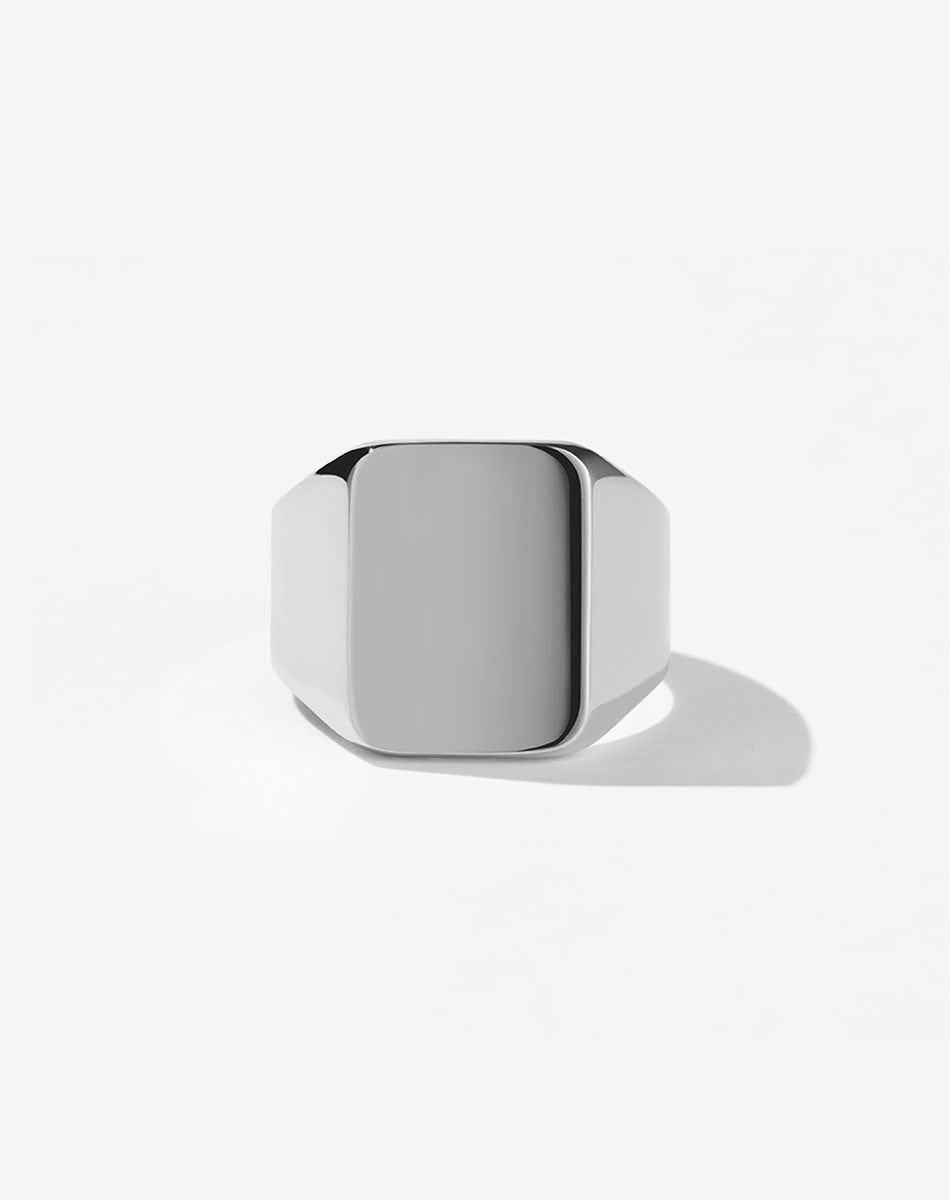 An oversized sterling silver signet ring with a flat rectangular platform for engraving.