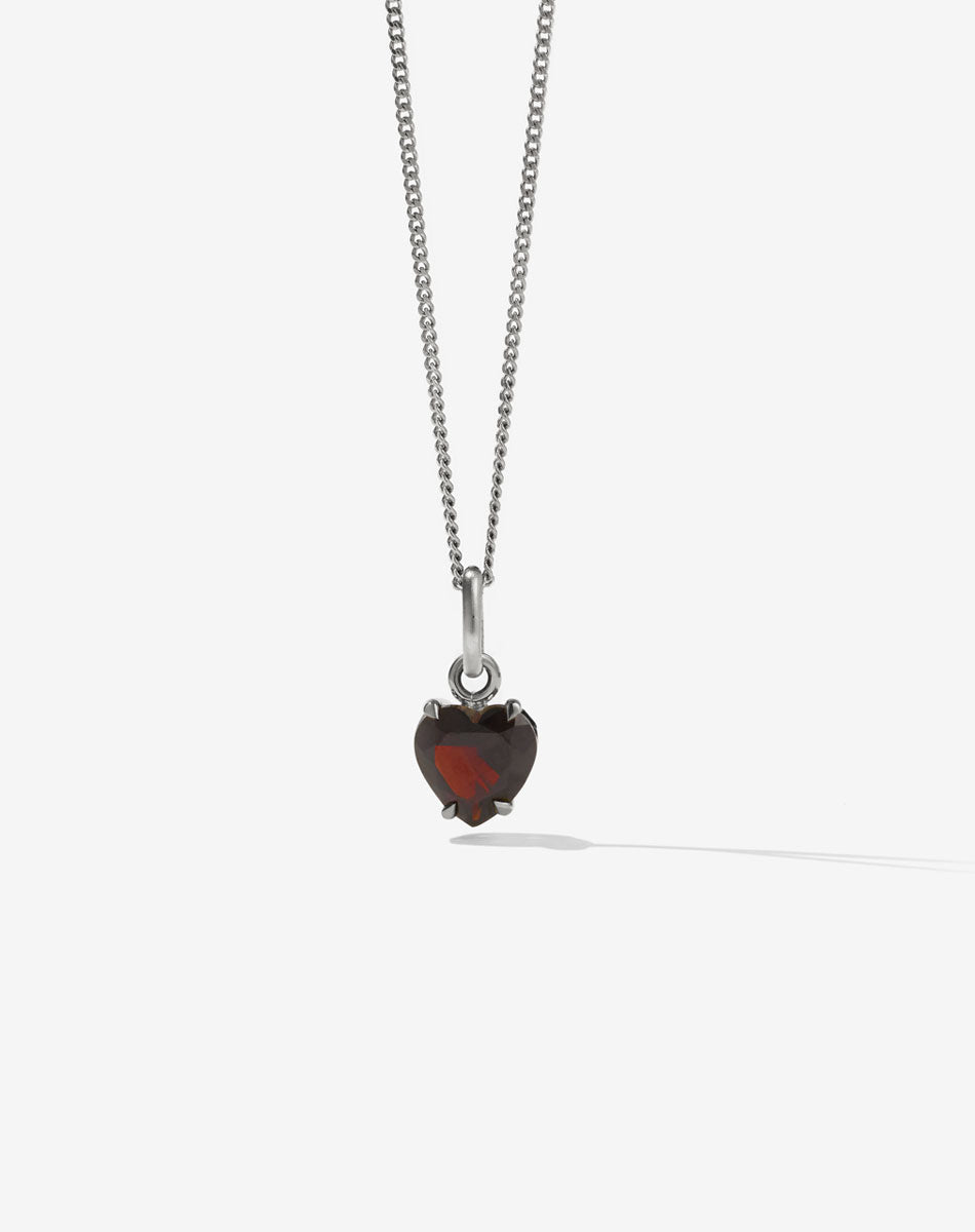 A heart-shaped Thai Garnet necklace with a sterling silver chain and claw setting.