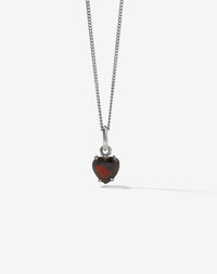 A heart-shaped Thai Garnet necklace with a sterling silver chain and claw setting.