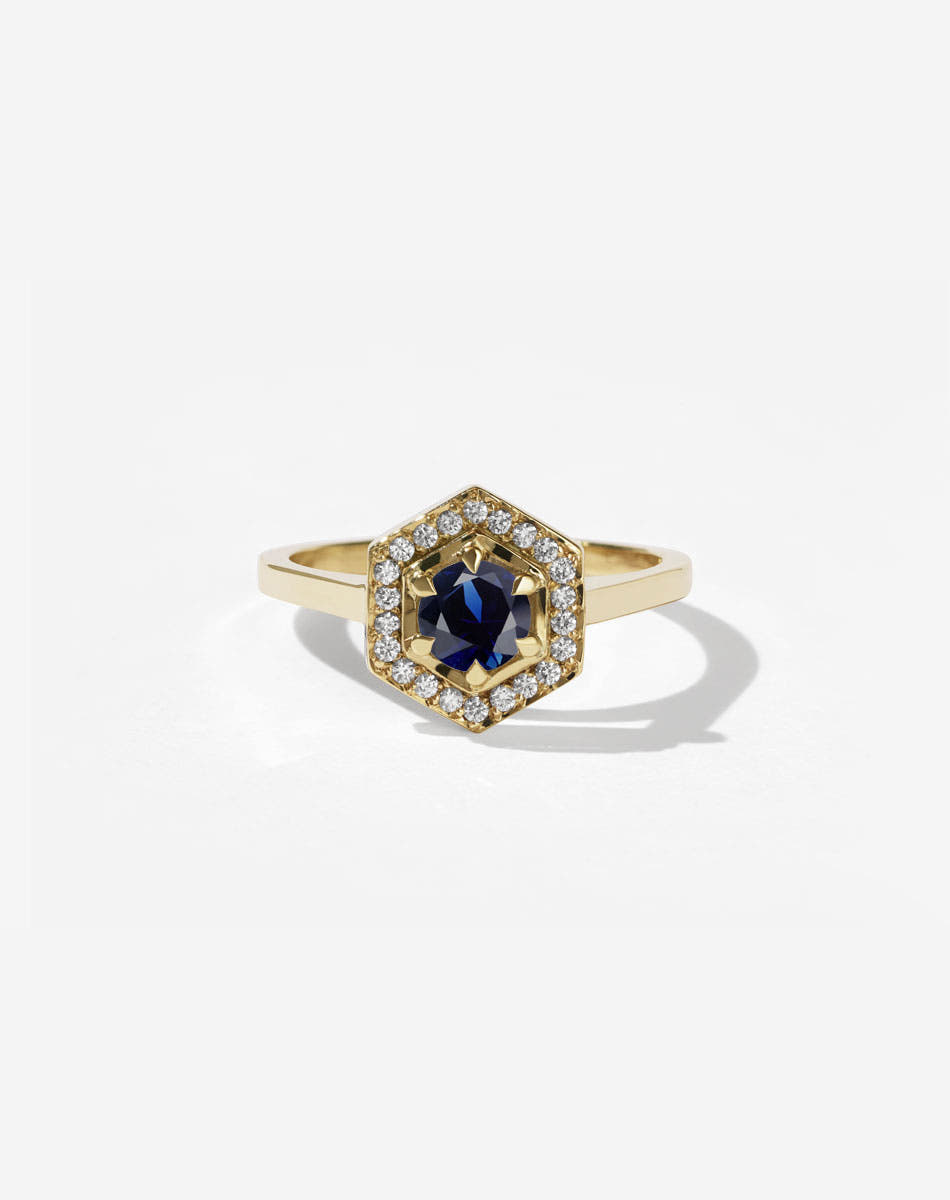 Meadowlark Jewellery’s iconic Hex Engagement Ring 0.5ct in 18ct Yellow Gold, claw set with 0.61ct round brilliant cut blue sapphire centre stone, surrounded by a hexagon halo of pave set white diamonds. Fully traceable and ethically sourced blue and green sapphires from Queensland, Australia. One of our most beloved and modern Ceremonial designs, made to order in New Zealand. Pair with our bestseller, the Diamond Eternity Band.