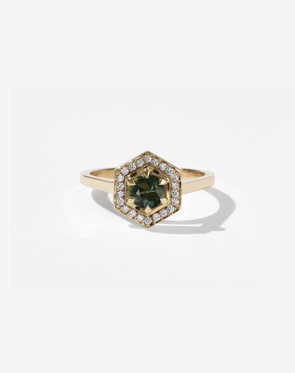 Meadowlark Jewellery’s iconic Hex Engagement Ring 0.5ct in 9ct Yellow Gold, claw set with 0.61ct round brilliant cut green sapphire centre stone, surrounded by a hexagon halo of pave set white diamonds. Fully traceable and ethically sourced blue and green sapphires from Queensland, Australia. One of our most beloved and modern Ceremonial designs, made to order in New Zealand. Pair with our bestseller, the Diamond Eternity Band.