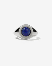 A sterling silver ring with a central blue lapis lazuli stone set in a rounded signet style.