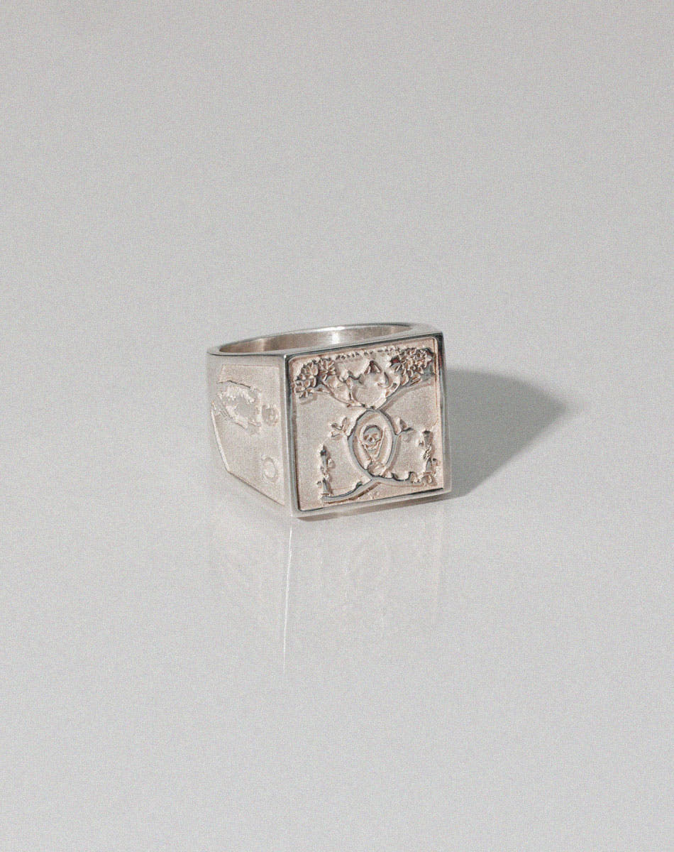 A heavy weighted sterling silver ring with a  collage artwork design.