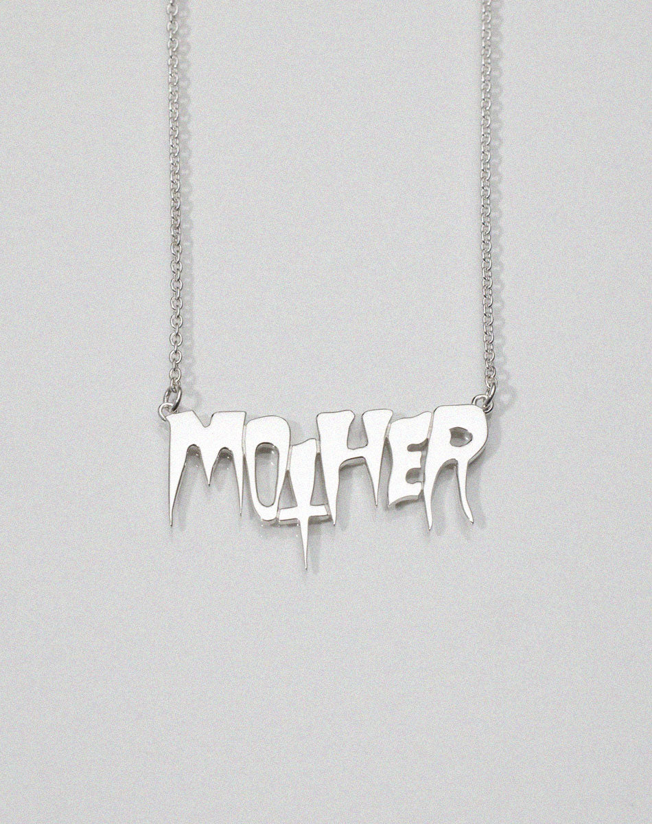 A sterling silver necklace with the word 'MOTHER' as the central pendant, attached to a fine chain. In collaboration with Australian artist Nell. Real life