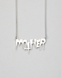 A sterling silver necklace with the word 'MOTHER' as the central pendant, attached to a fine chain. In collaboration with Australian artist Nell. Real life