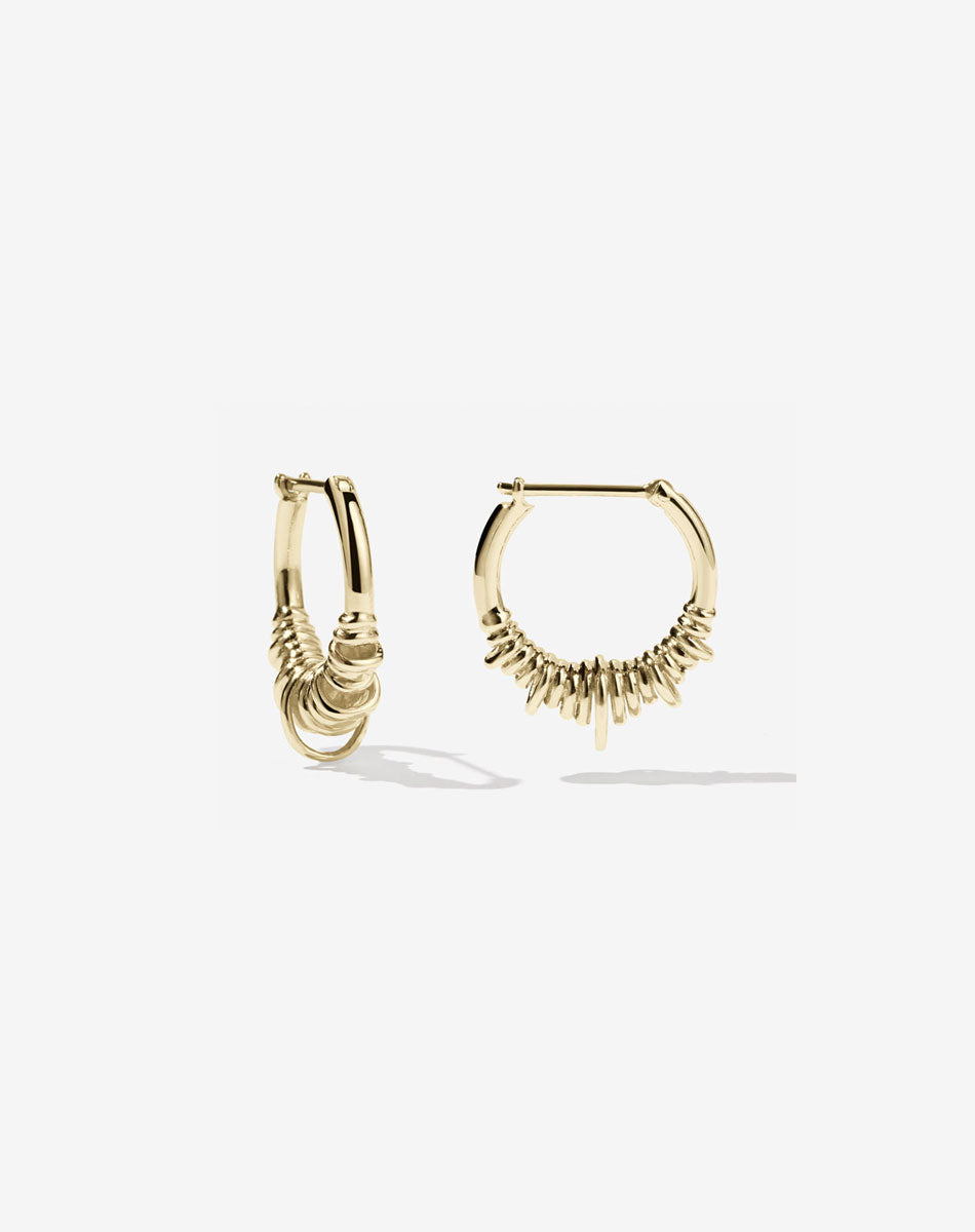 A pair of small hoop earrings made of gold, with a series of rings suspended on a hoop.