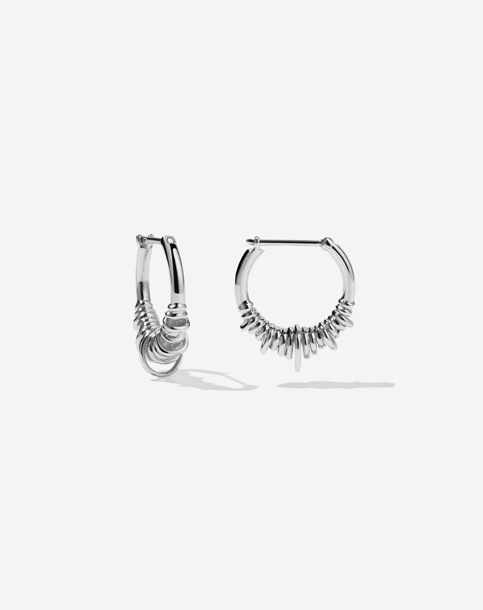 A pair of small hoop earrings made of sterling silver, with a series of rings suspended on a hoop.
