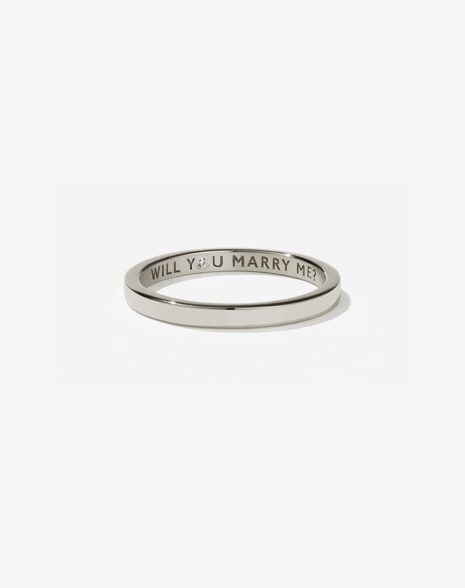 Meadowlark Jewellery’s 0.10ct Stand In Ring in 9ct White Gold, engraved with ‘will you marry me’ and swiss set with a round brilliant cut white diamond. A 2mm wide minimalist placeholder or proposal ring. This Ceremonial design can be worn as a wedding band and is made to order in New Zealand.