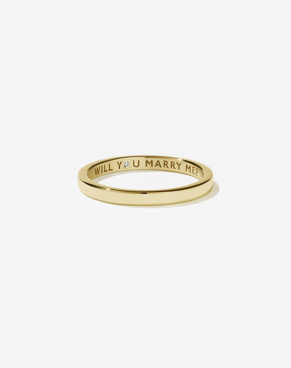 Meadowlark Jewellery’s 0.10ct Stand In Ring in 9ct Yellow Gold, engraved with ‘will you marry me’ and swiss set with a round brilliant cut white diamond. A 2mm wide minimalist placeholder or proposal ring. This Ceremonial design can be worn as a wedding band and is made to order in New Zealand.