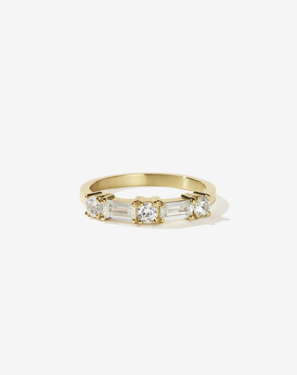 Meadowlark Jewellery’s modern 0.73ct Stella Engagement Ring in 18ct Yellow Gold, claw set with two baguette cut white diamonds and three round brilliant cut white diamonds. Atop a fine square band. A Ceremonial design made to order in New Zealand. Wear as a wedding band with our Hilma Ring or alternative engagement ring.