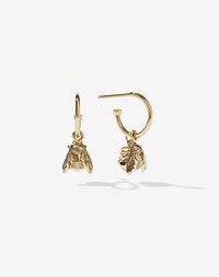 A pair of gold-colored hoop earrings with intricately-sculpted bee charms suspended from them.