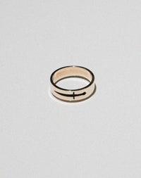 A gold ring featuring an etched and oxidised dagger design on a band.