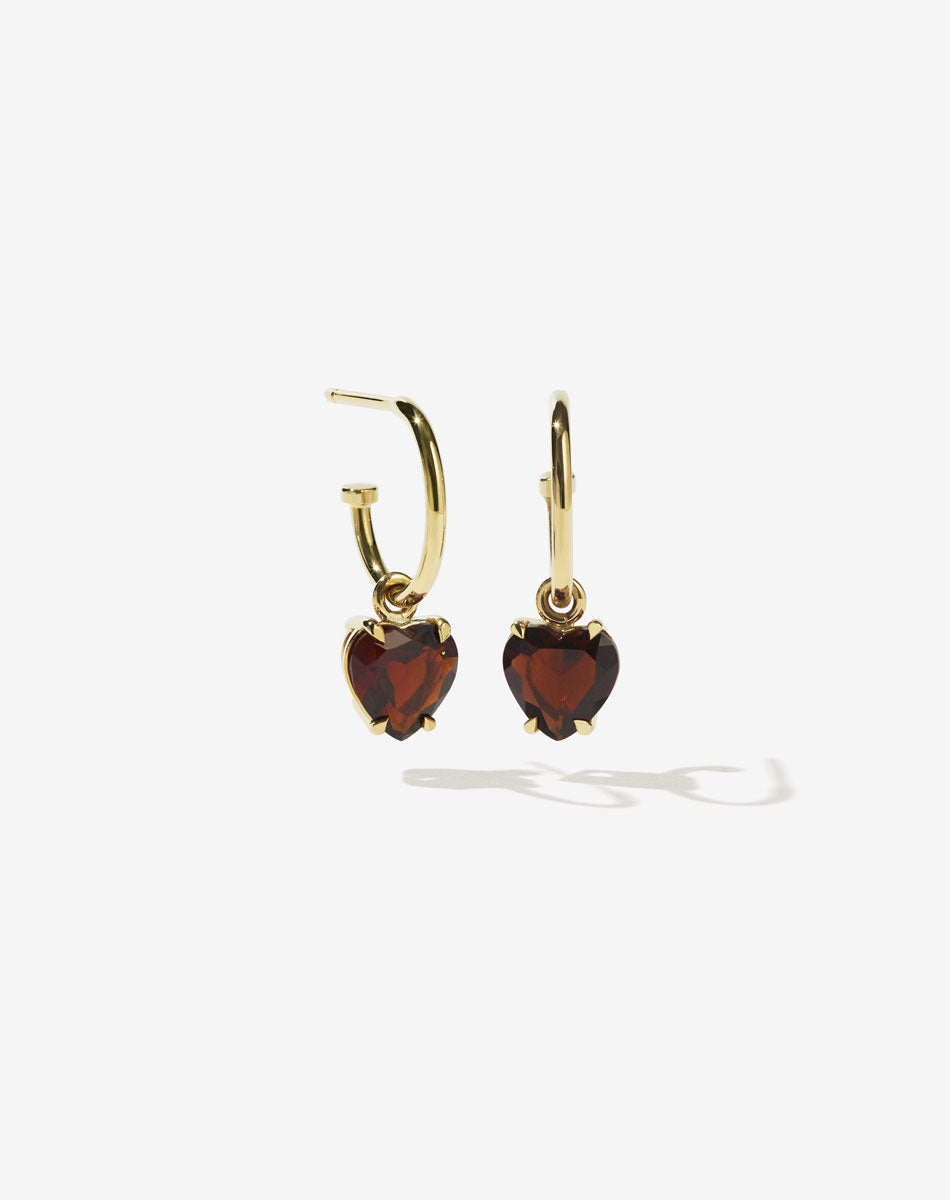 A pair of heart-shaped garnet earrings set in a claw setting, suspended from small hoop earrings, crafted in 9ct solid gold.