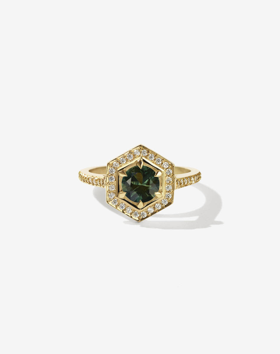 Meadowlark Jewellery’s iconic Hex Engagement Ring in 18ct Yellow Gold, claw set with round brilliant cut green sapphire centre stone, surrounded by a hexagon halo of pave set white diamonds. Fully traceable and ethically sourced blue and green sapphires from Queensland, Australia. Finished with a fine square band, diamond pave set halfway. One of our most beloved and modern Ceremonial designs, made to order in New Zealand. Pair with our bestseller, the Diamond Eternity Band.