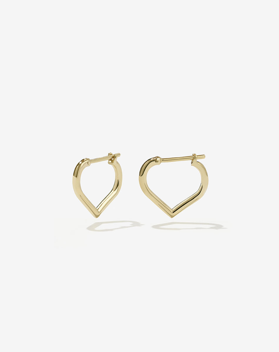 A pair of small heart-shaped hoop earrings made of gold.