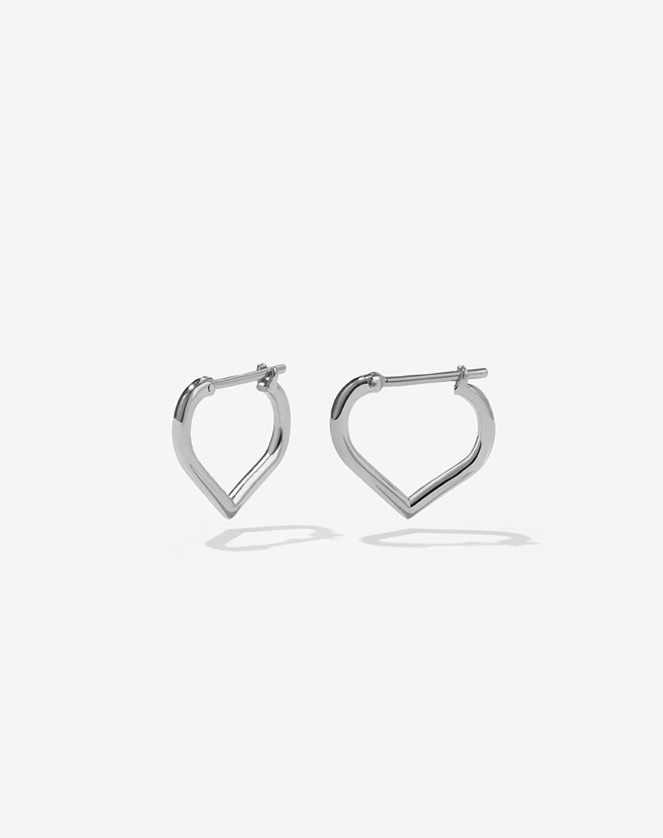 A pair of heart shaped sterling silver hoop earrings.