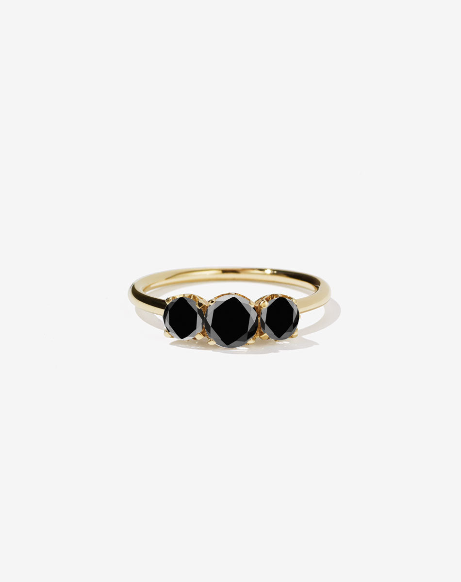 A classic three stone engagement ring in yellow gold with black diamonds.