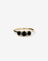 A classic three stone engagement ring in yellow gold with black diamonds.