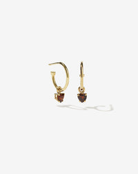 A pair gold plated hoop earrings with heart-shaped garnet stones set in claw settings.