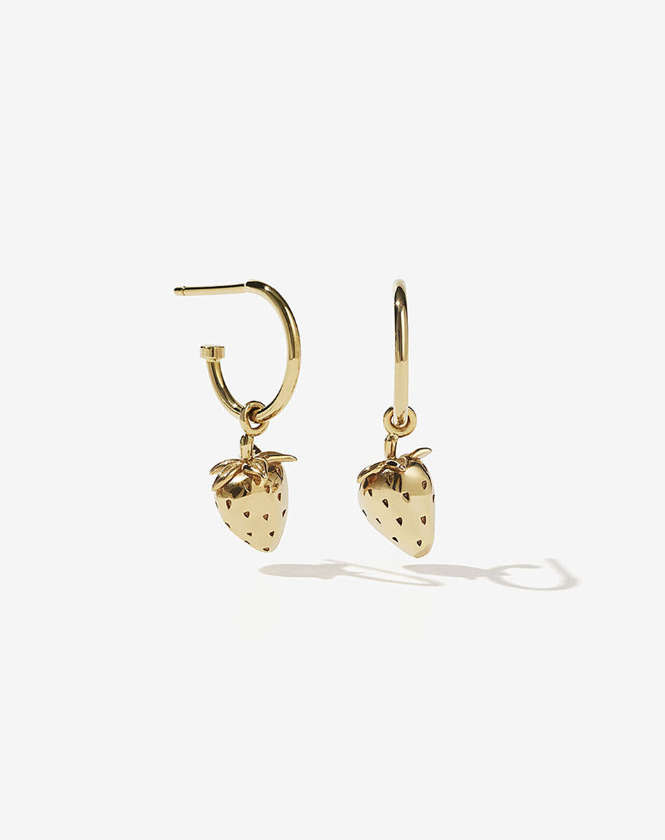 A pair of gold-plated hoop earrings with strawberry charms attached, displayed against a white background.