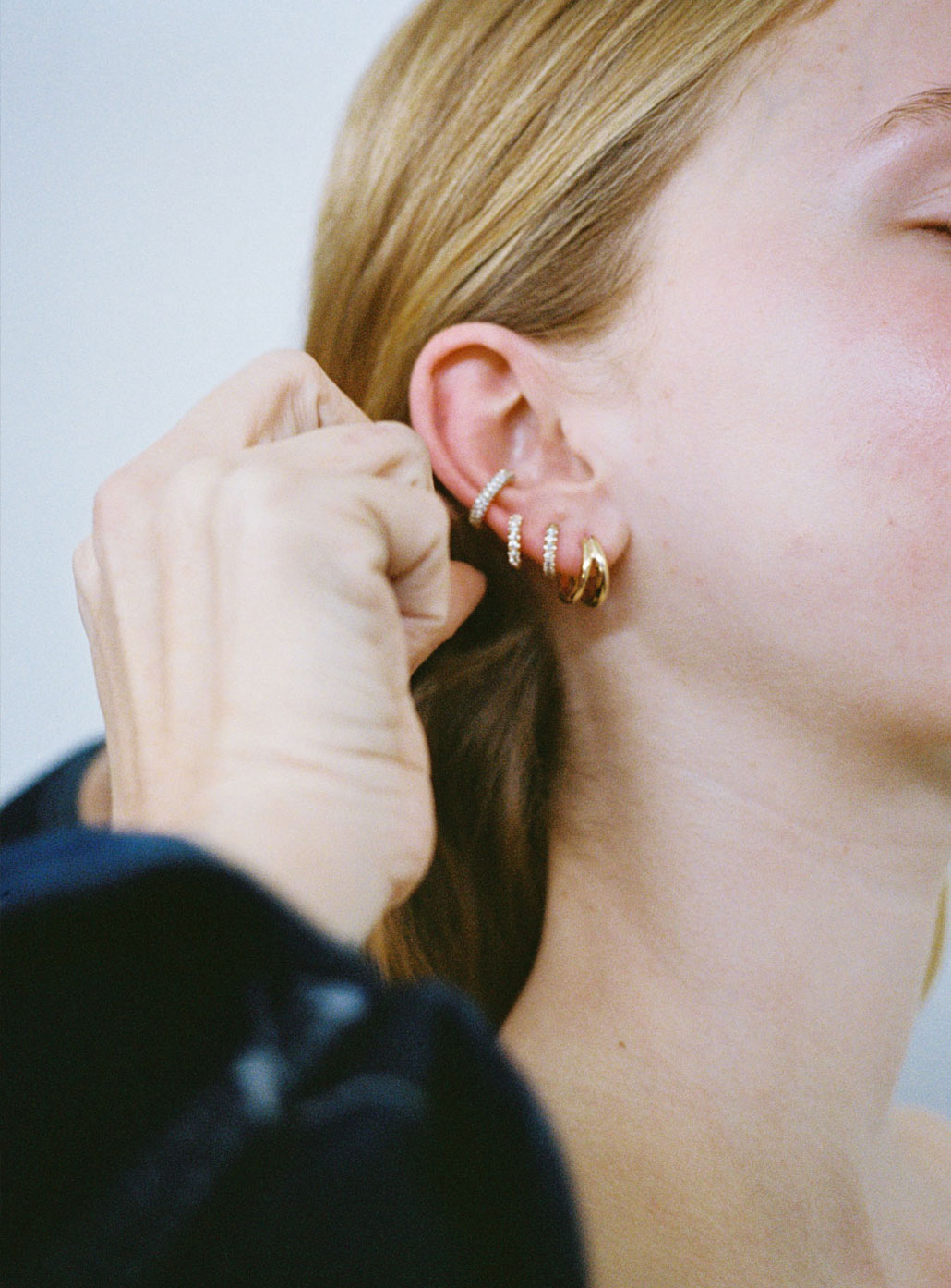Meadowlark Jewllery's Halo Ear Cuff Triple Pave Small, Halo Huggies Pave, Coco Hoop Earrings Medium in 9ct Yellow Gold with round brilliant cut white diamonds. Worn stacked on model ear.
